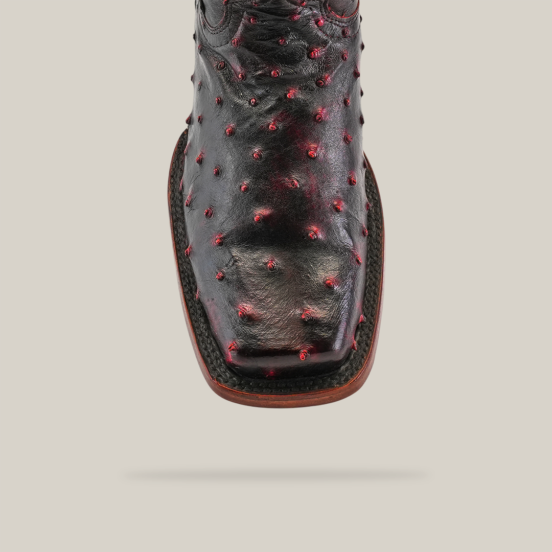 Close-up of an Exotic Ostrich - Black Cherry boot featuring a Rodeo toe, intricate red dot embellishments, and detailed stitching on black ostrich leather, set against a plain white background.
