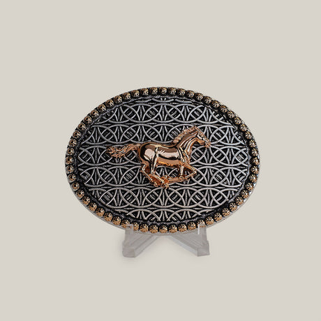 The Racing Horse Buckle is an oval belt accessory featuring a gold horse design at its center amidst intricate geometric patterns, reminiscent of classic Texas buckles. It includes small gold accents along the edge and is displayed on a clear stand against a neutral background.
