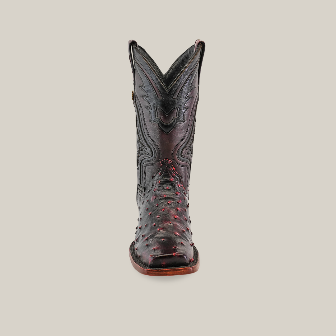 The Exotic Ostrich - Black Cherry cowboy boot boasts a genuine ostrich leather construction with intricate stitching and red accents. Displayed against a white background, it highlights its craftsmanship and unique rodeo toe design.