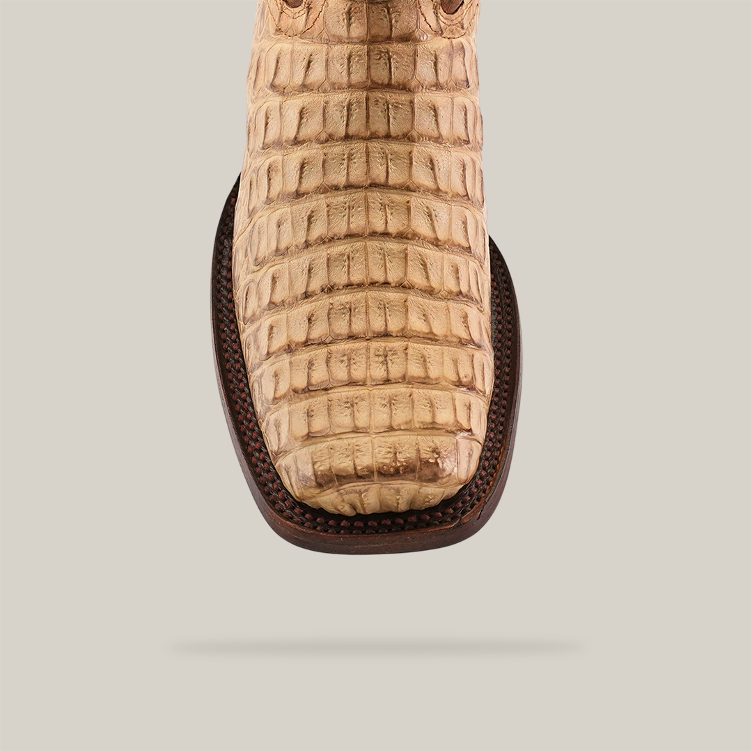 Close-up of the Exotic Caiman Hornback - Orix boot with a textured pattern and squared Rodeo toe. Crafted from premium leather, it features a light brown hue and dark brown stitching.